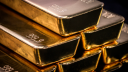 El oro cae 1% por alza del dólar y postura comercial menos agresiva de Trump
